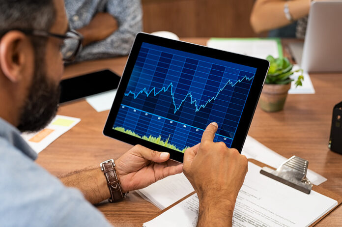 Mature latin businessman reading business graphs and stock chart
