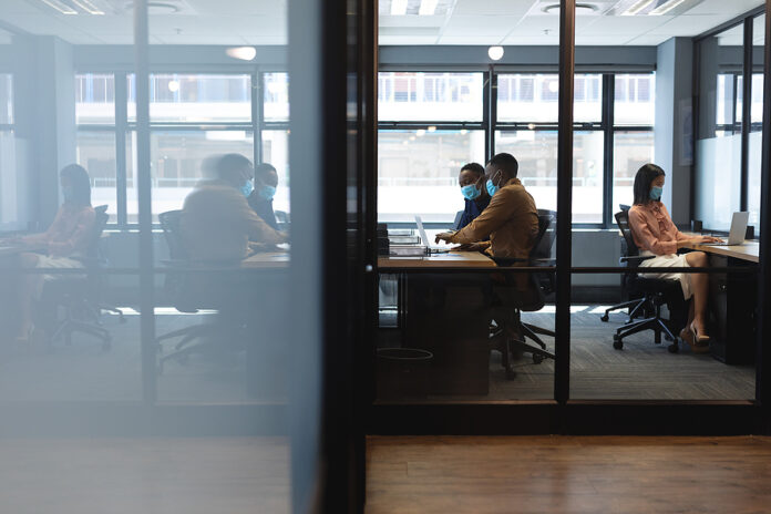 Diverse colleagues wearing face masks working in office. hygiene