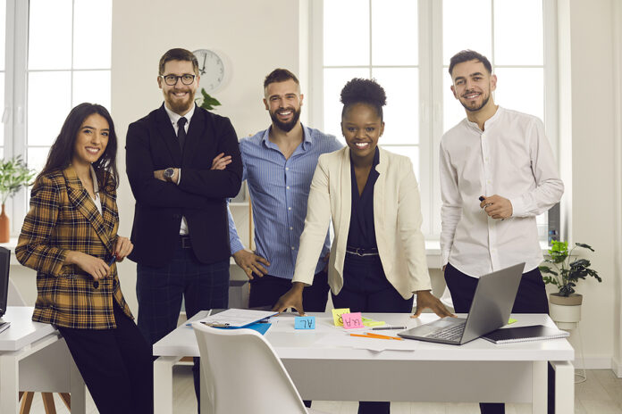 Team Of Happy Young Diverse Business People Standing In Modern O