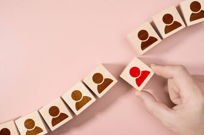 Hand Choosing A Wooden Person Block From A Set. Employment Choic