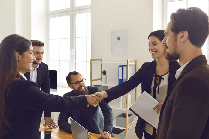 Happy Business People Closing Deal And Shaking Hands After Negot