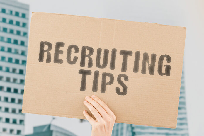 The Phrase " Recruiting Tips " On A Banner In Men's Hand With Bl
