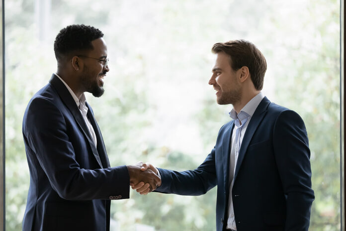 Two Diverse Businessmen, Business Partners Shaking Hands At Wind