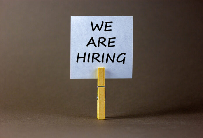 Wooden Clothespin With White Sheet Of Paper. Text 'we Are Hiring