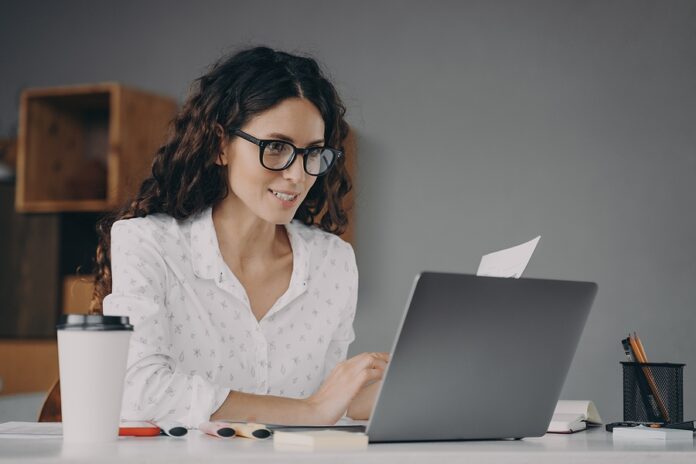 Happy European Woman In Glasses Working On Modern Laptop From Ho