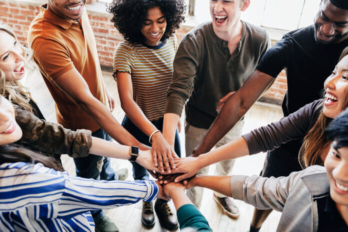 Group of diverse people stacking hands in the middle