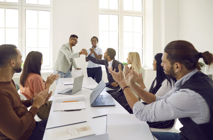 Happy Man Shakes Hands With His Colleague While Diverse Business