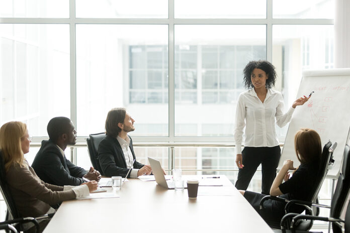 African American Businesswoman Giving Presentation To Executive