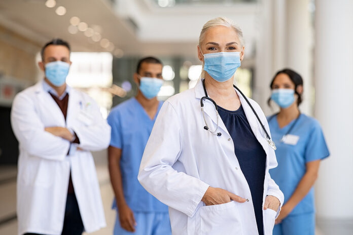 Portrait of smiling woman doctor looking at camera and standing