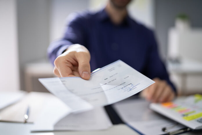 Businessperson Hands Giving Cheque To Other Person