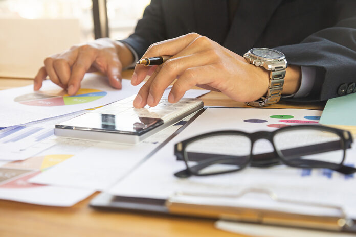 Businessman Or Accountant Working On Calculator To Calculate Bus