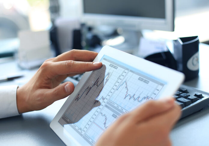 Business person analyzing financial statistics displayed on the tablet screen