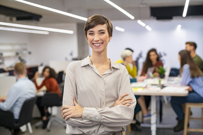 Successful young woman standing in front of businesspeople and s
