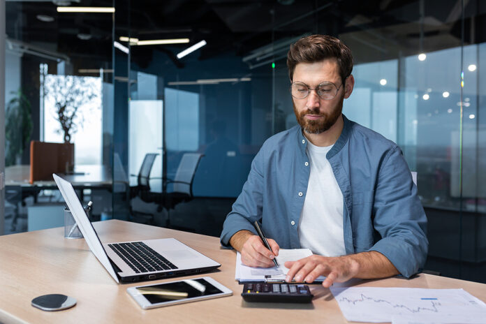 Serious And Focused Financier Accountant On Paper Work Inside Of