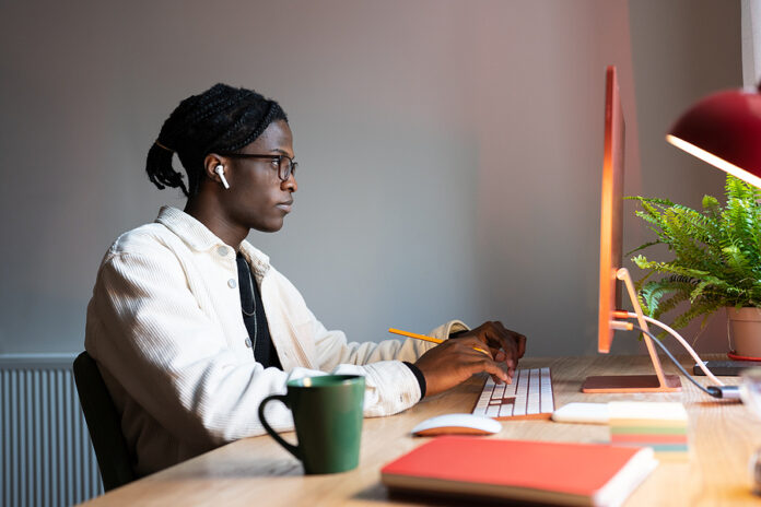 Focused Concentrated African Man Freelance Web Developer Wearing