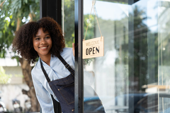 Small Business African Female Owner Smiling While Turning Sign F