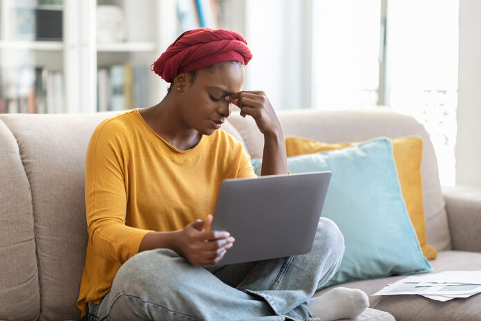 Exhausted Young Black Woman Using Computer At Home, Feeling Tire