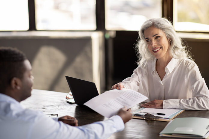 Male Job Applicant Giving Cv To Female Manager In Office