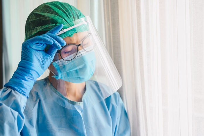 Nurse Having Tired From Work While Wearing Ppe Suit For Protect