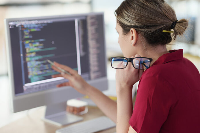 Female Programmer Checks Code Looking At Screen Of Computer Moni