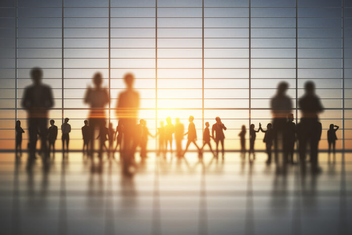 Backlit Crowd Of Businesspeople Working Together In Bright Offic