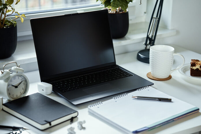 Home Office Workplace With Laptop, Documents And Cup Of Tea Plac