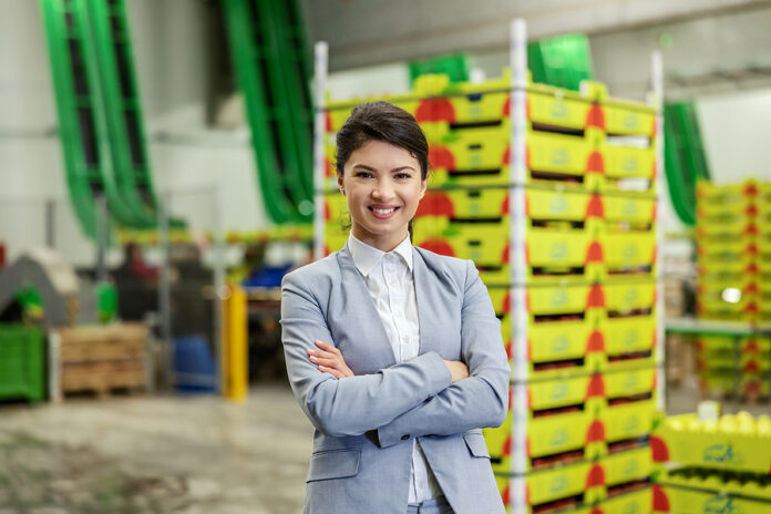 Businesswoman In A Warehouse. A Lady With Style Dressed In A Bus