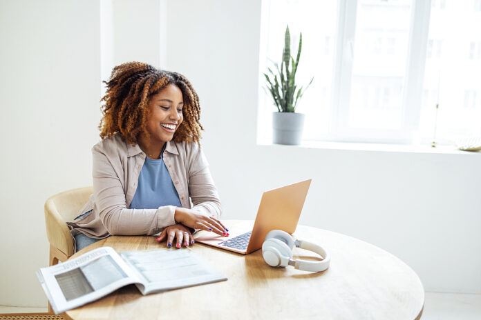 Young African American Woman Is Working On A Laptop. Happy Femal