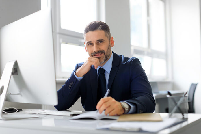 Portrait Of Happy Middle Aged Man Entrepreneur Working On Comput