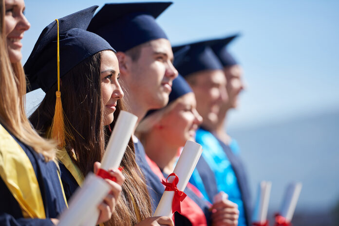 young graduates students group standing in front of university