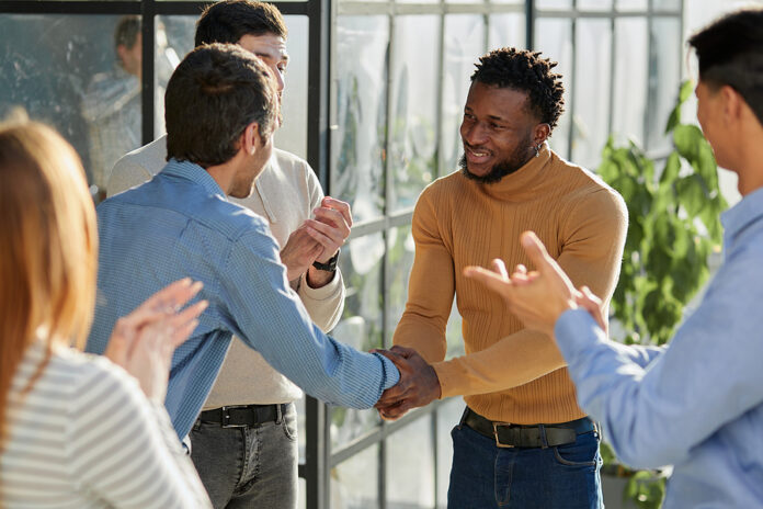 Smiling Multiethnic Friend Getting Acquainted In Office Corridor