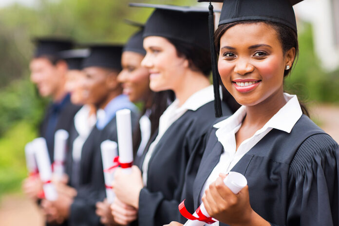 pretty african female college graduate at graduation with classm