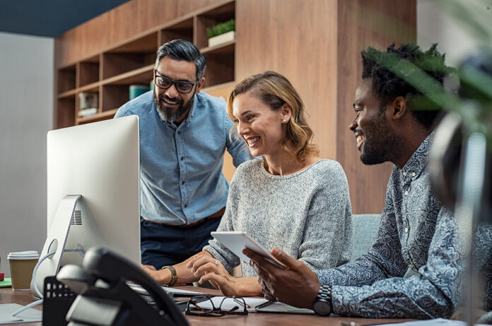 Casual businessmen and cheerful business woman in office working