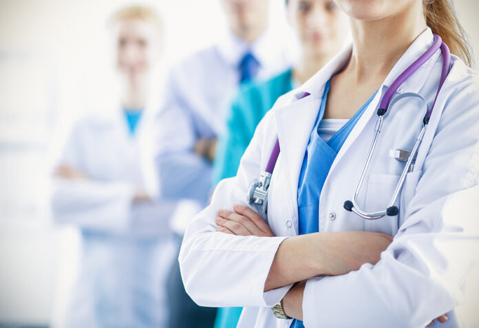 Attractive female doctor in front of medical group