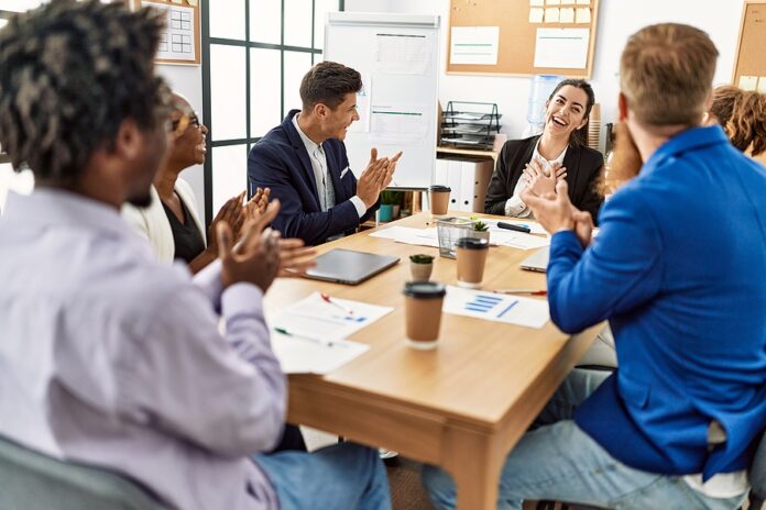 Group of business workers smiling and clapping to partner at the