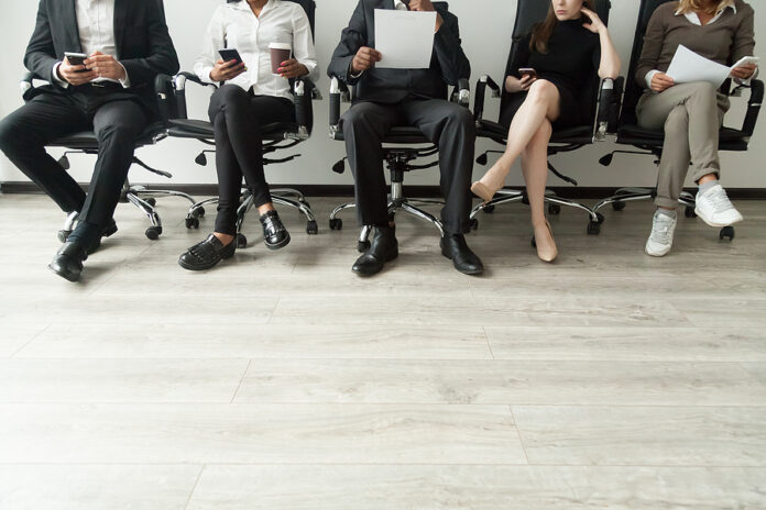 Diverse Business People Waiting In Queue Holding Smartphones And