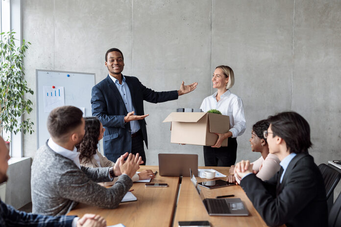 Businessman Introducing New Business Team Member To Employees Co