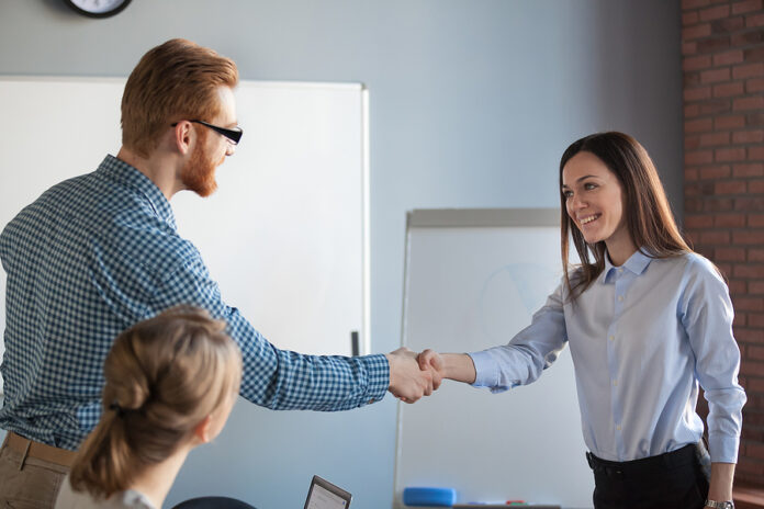 Male Recruiter Handshaking Female Job Candidate After Successful
