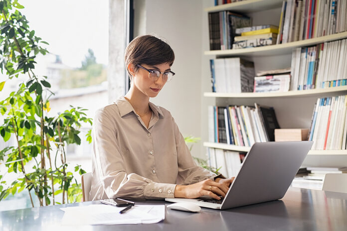 Young businesswoman sitting on her workplace in the office and w